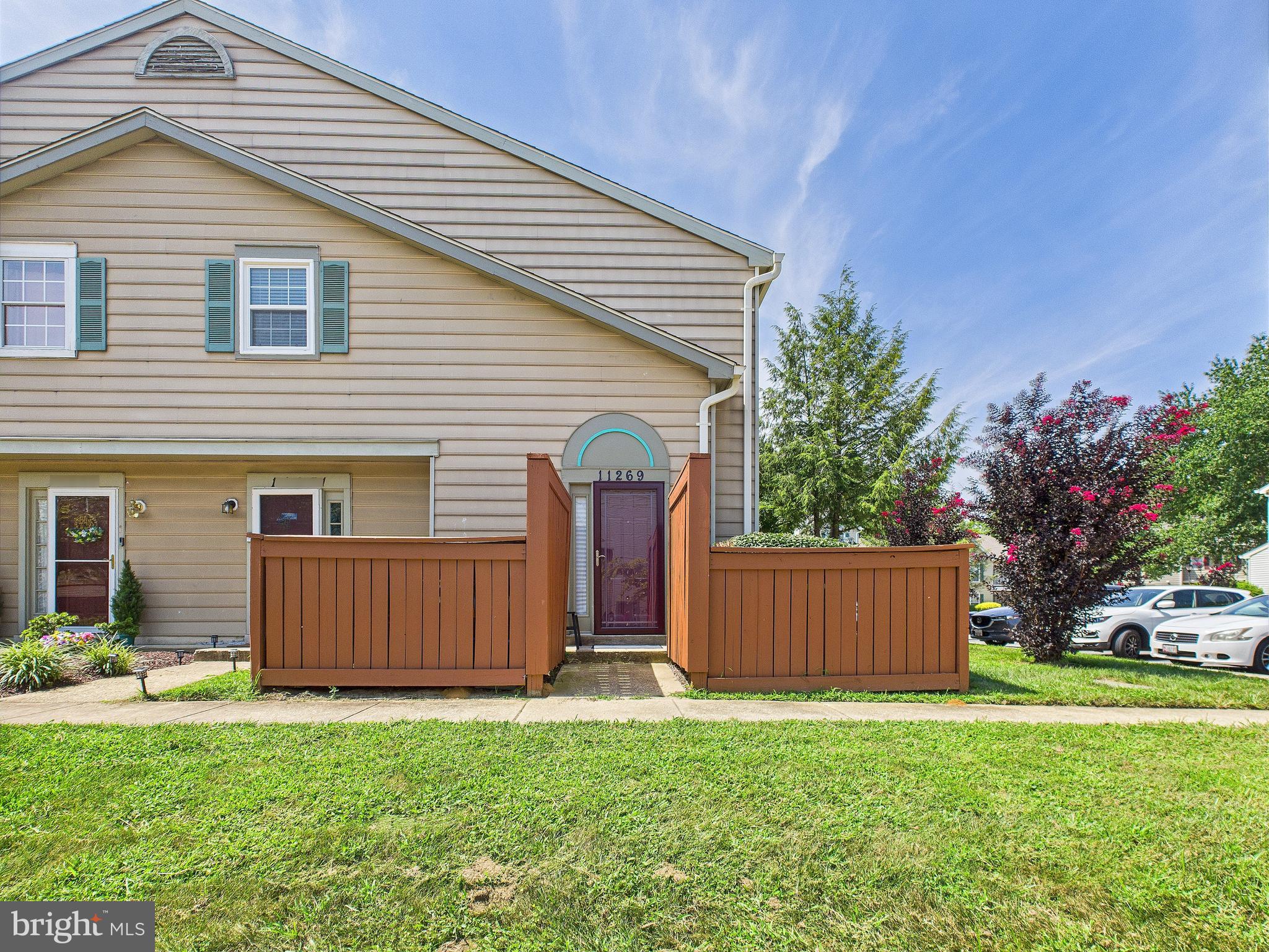 a front view of house with yard and car parked