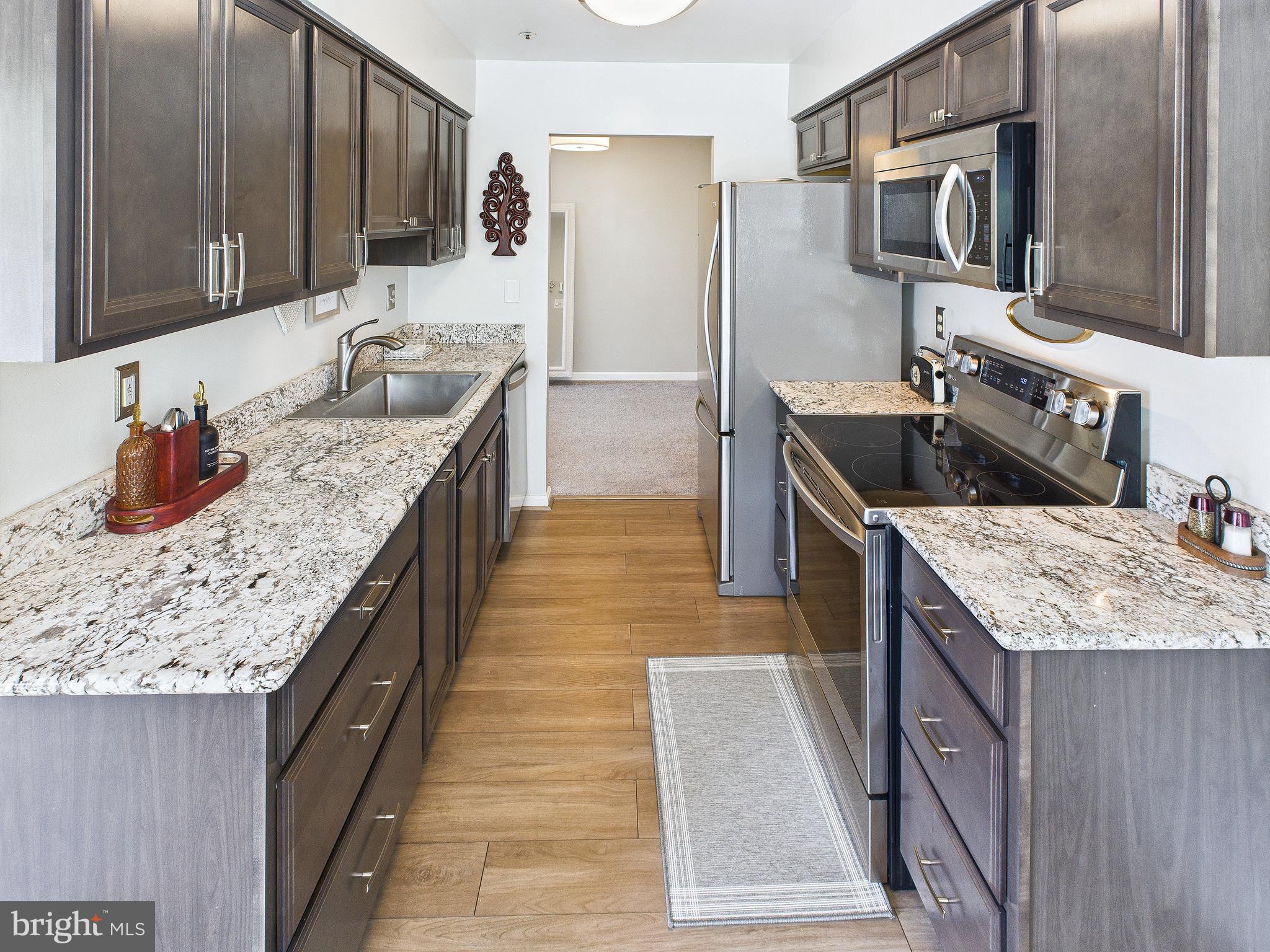 11269 Raging Brook Drive, Unit 258 Bowie, MD 20720 - Photo 18 of 36 a kitchen with stainless steel appliances granite countertop a sink stove and refrigerator
