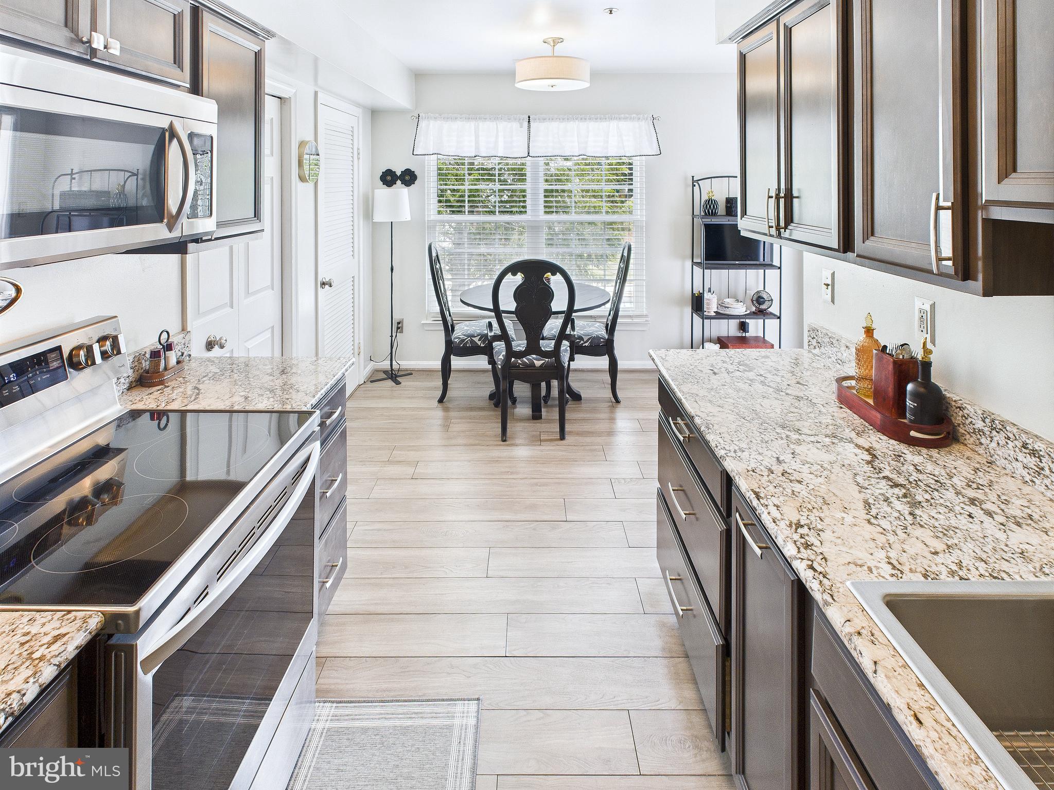 11269 Raging Brook Drive, Unit 258 Bowie, MD 20720 - Photo 19 of 36 a kitchen with granite countertop a sink and a stove top oven