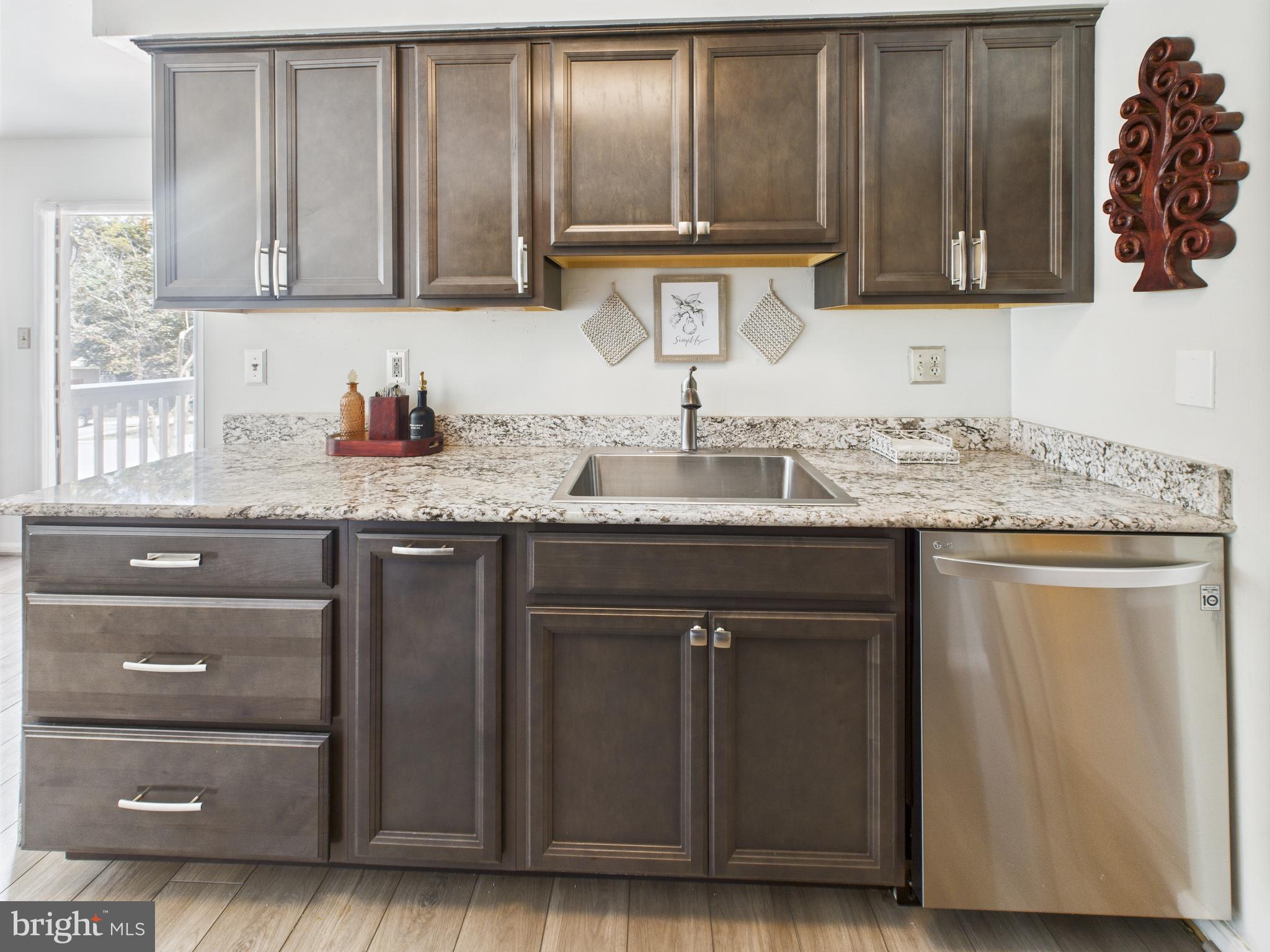 11269 Raging Brook Drive, Unit 258 Bowie, MD 20720 - Photo 21 of 36 a kitchen with granite countertop a sink and cabinets