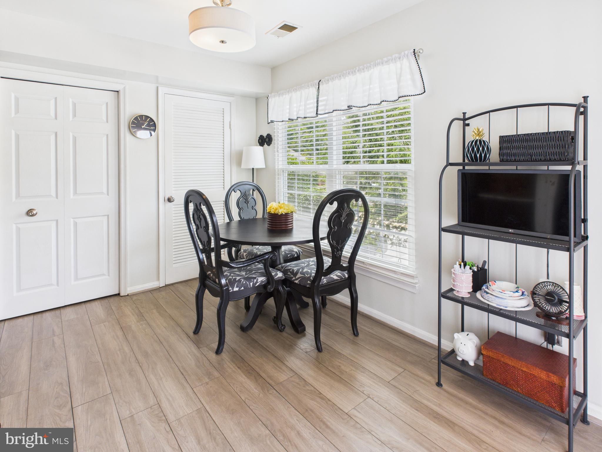 11269 Raging Brook Drive, Unit 258 Bowie, MD 20720 - Photo 23 of 36 a dining room with furniture and wooden floor