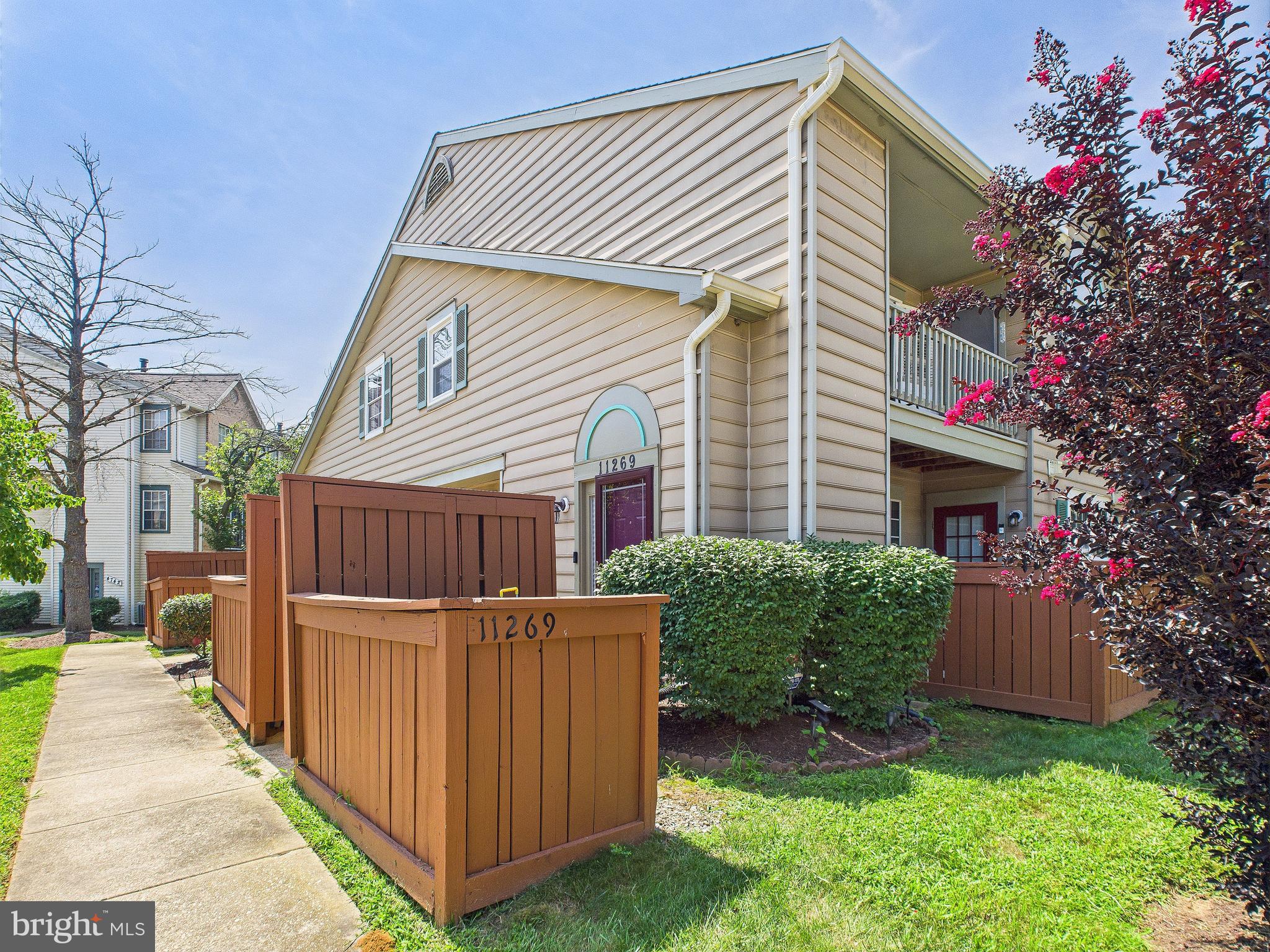 11269 Raging Brook Drive, Unit 258 Bowie, MD 20720 - Photo 3 of 36 a view of a house with brick walls and a yard with plants