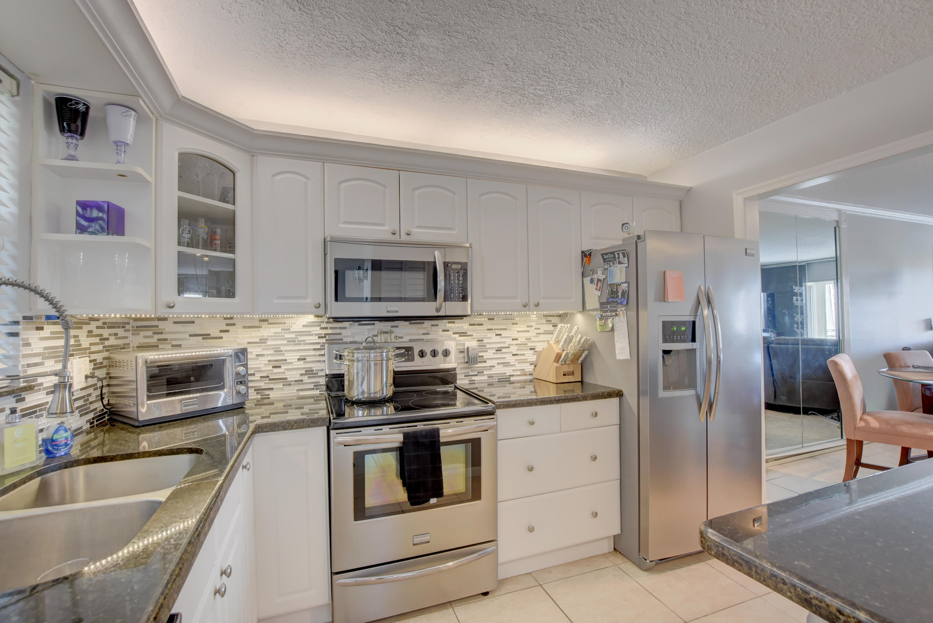 765 Jeffery Street, Unit 1306 Boca Raton, FL 33487 - Photo 9 of 34 a kitchen with stainless steel appliances kitchen island granite countertop a stove a sink and a refrigerator