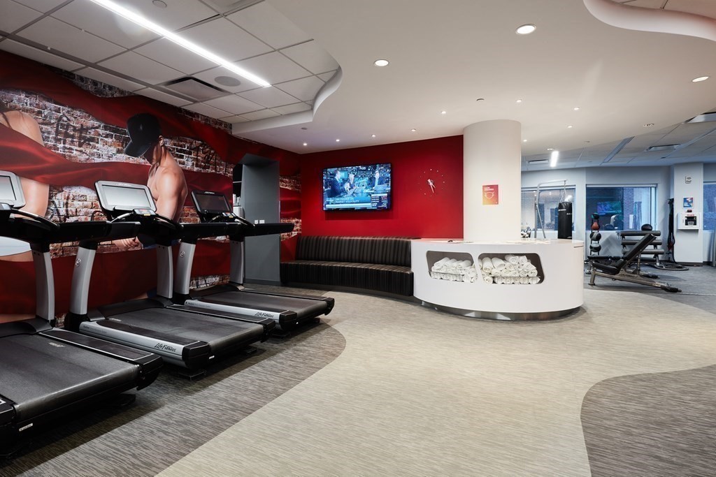 110 Stuart Street, Unit 19D Boston, MA 02116 - Photo 18 of 18 a living room with gym equipment and a flat screen tv