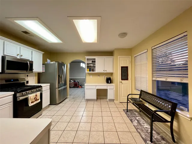 a kitchen with stainless steel appliances a refrigerator and a stove top oven