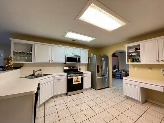 a kitchen with a sink a stove top oven and cabinets