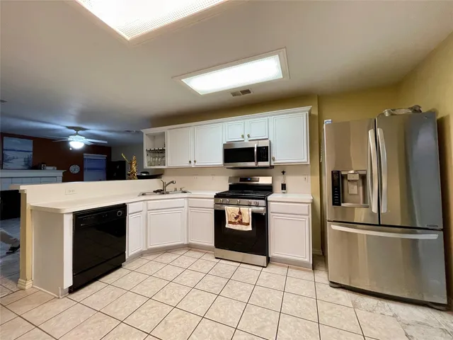 a kitchen with stainless steel appliances granite countertop a refrigerator sink and cabinets