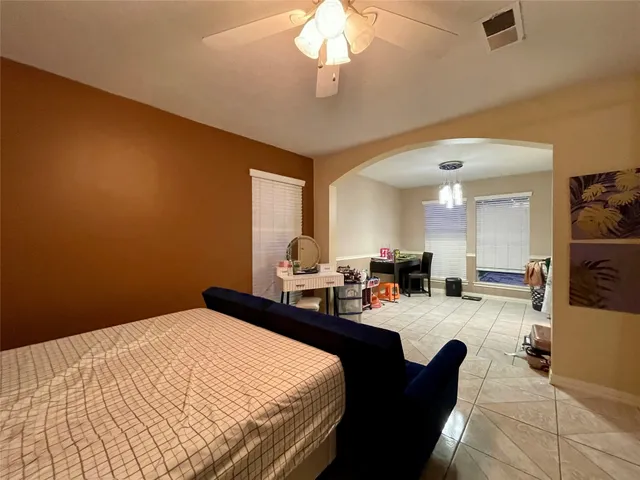 a bedroom with a bed a table and potted plant