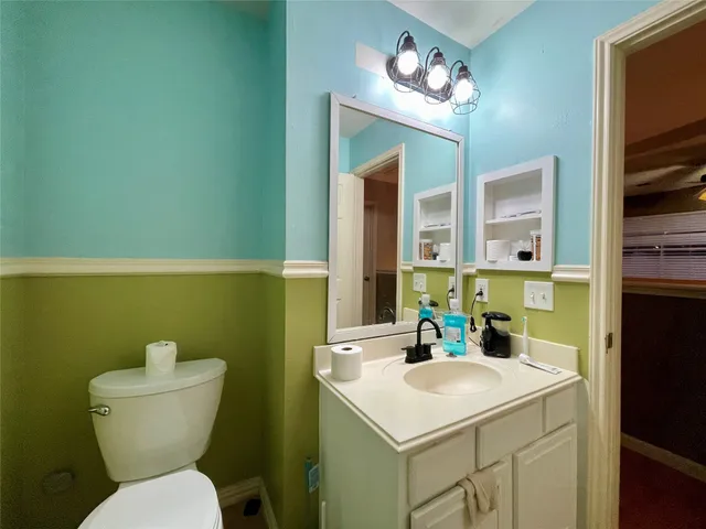 a bathroom with a toilet a sink and a mirror