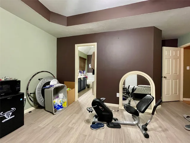 a living room with furniture a mirror and a wooden floor