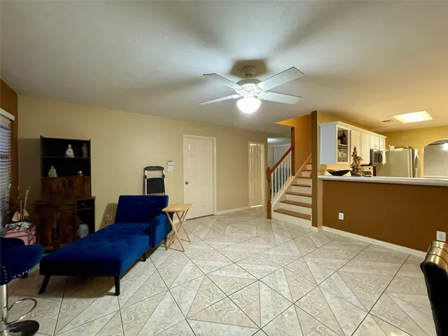 a living room with a couch and a dining table with wooden floor