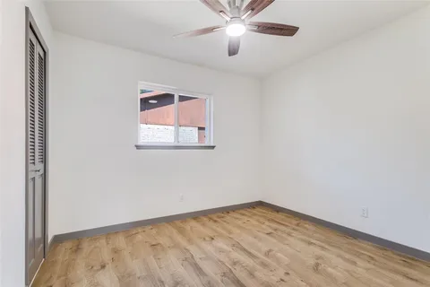 an empty room with a window and a fan