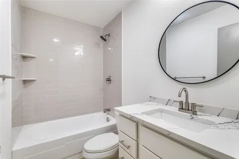 a bathroom with a granite countertop sink a toilet and a mirror