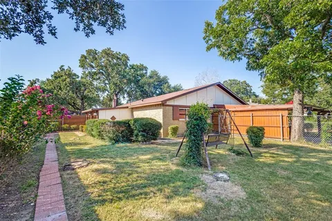 a view of a house with backyard and a tree