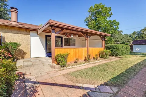 a front view of a house with a yard and potted plants