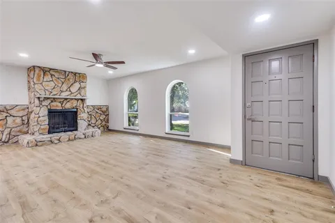 an empty room with windows and fireplace