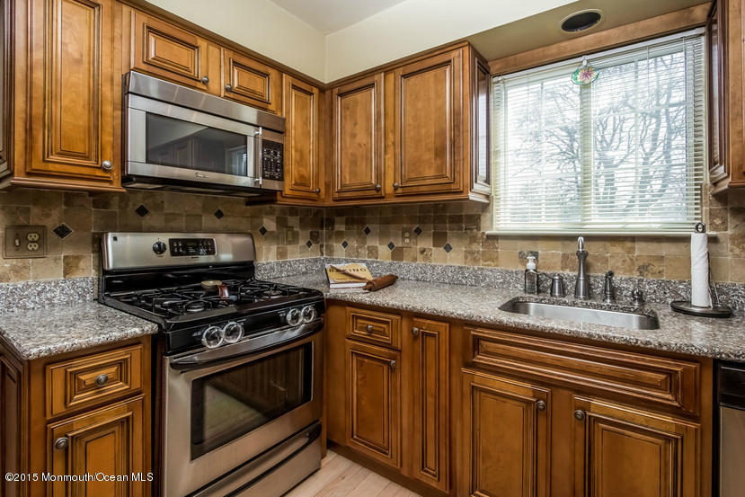 17 Rizzo Court Howell, NJ 07731 - Photo 5 of 15 a kitchen with granite countertop a sink stove and microwave