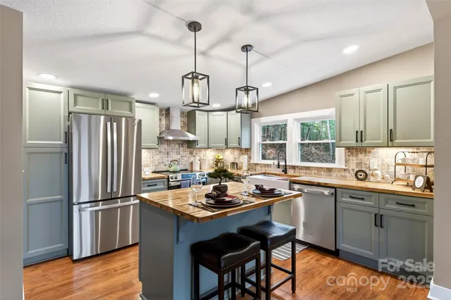 a kitchen with a center island appliances and cabinets