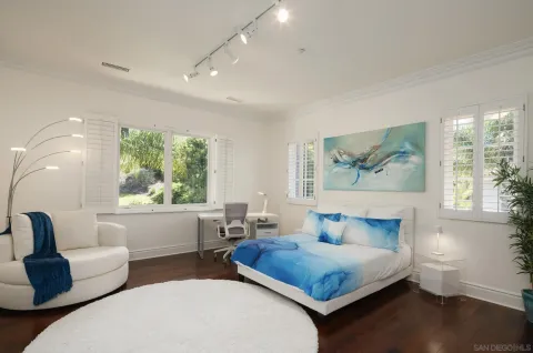 a bedroom with furniture and a large window