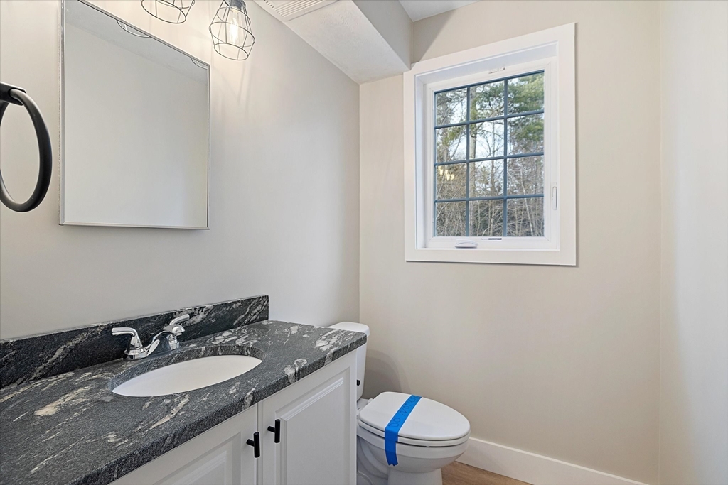 60 Hill Road, Unit B Charlton, MA 01507 - Photo 6 of 11 a bathroom with a granite countertop sink toilet a mirror and a window