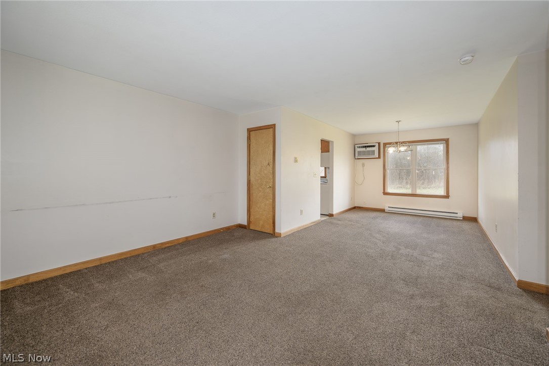 8464-8446 Tallmadge Road Diamond, OH 44412 - Photo 6 of 39 Carpeted empty room with a baseboard radiator and a chandelier