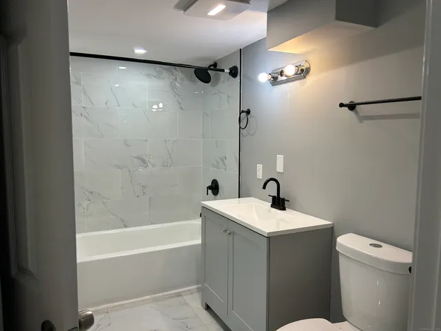 a bathroom with a sink a toilet and shower
