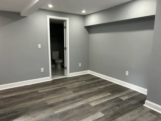 a view of an empty room with wooden floor