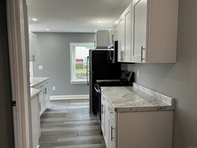 a view of a kitchen with cabinets and wooden floor