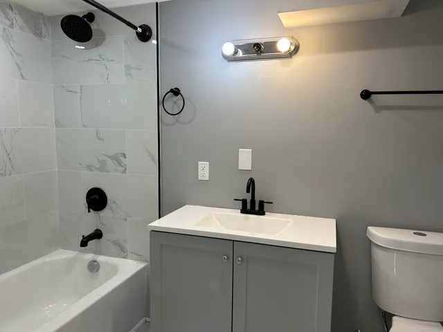 a bathroom with a sink and mirror with toilet