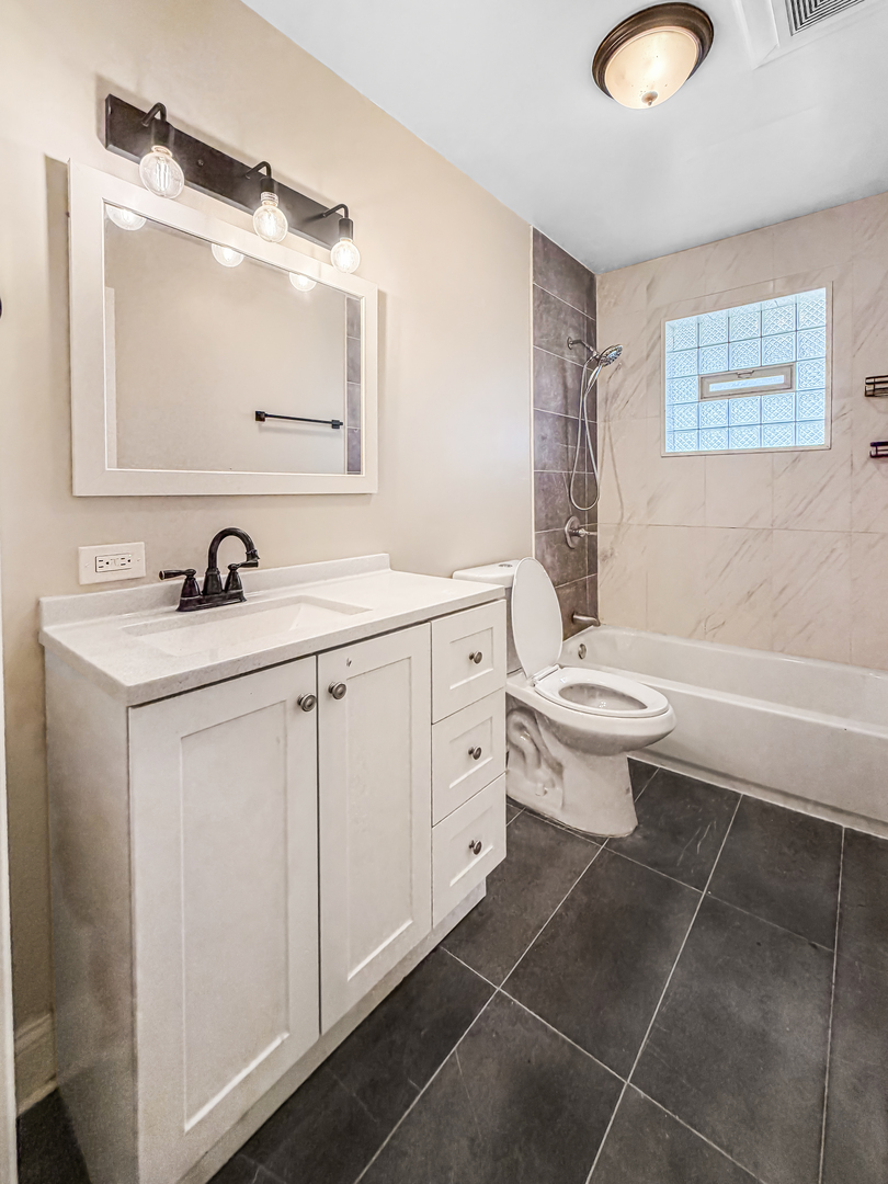 7241 Beloit Avenue Bridgeview, IL 60455 - Photo 12 of 26 a bathroom with a toilet sink and mirror