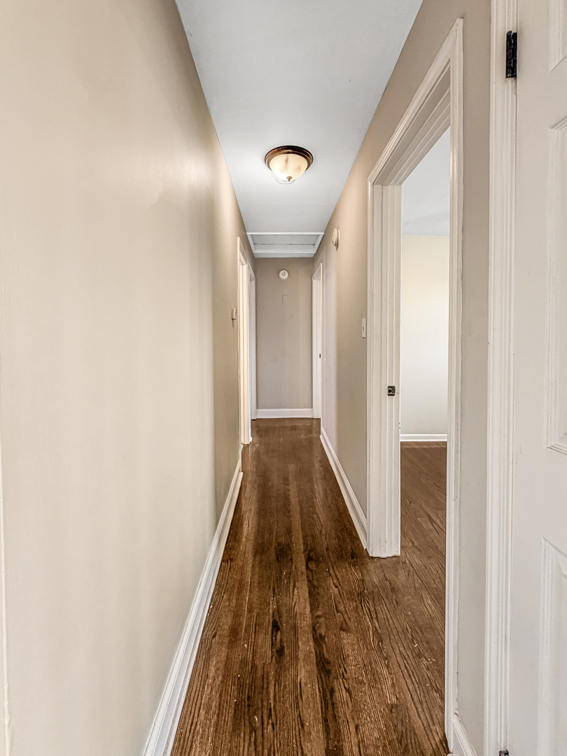7241 Beloit Avenue Bridgeview, IL 60455 - Photo 15 of 26 a view of a hallway with wooden floor and a bathroom