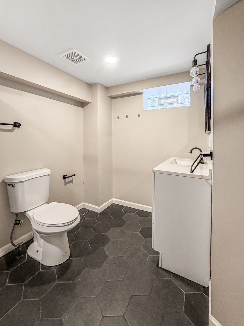 7241 Beloit Avenue Bridgeview, IL 60455 - Photo 23 of 26 a bathroom with a toilet sink and mirror