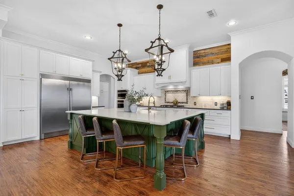 a kitchen with stainless steel appliances granite countertop a kitchen island a stove a table and chairs in it