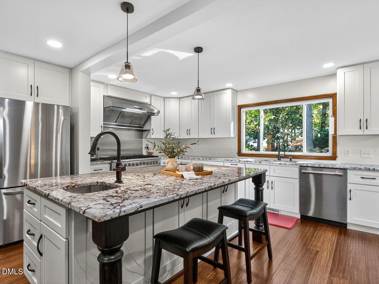509 Holtz Lane Cary, NC 27511 - Photo 5 of 42 a kitchen with stainless steel appliances granite countertop a stove a refrigerator a sink dishwasher a dining table and chairs with wooden floor