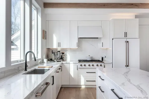 a kitchen with white cabinets appliances and sink