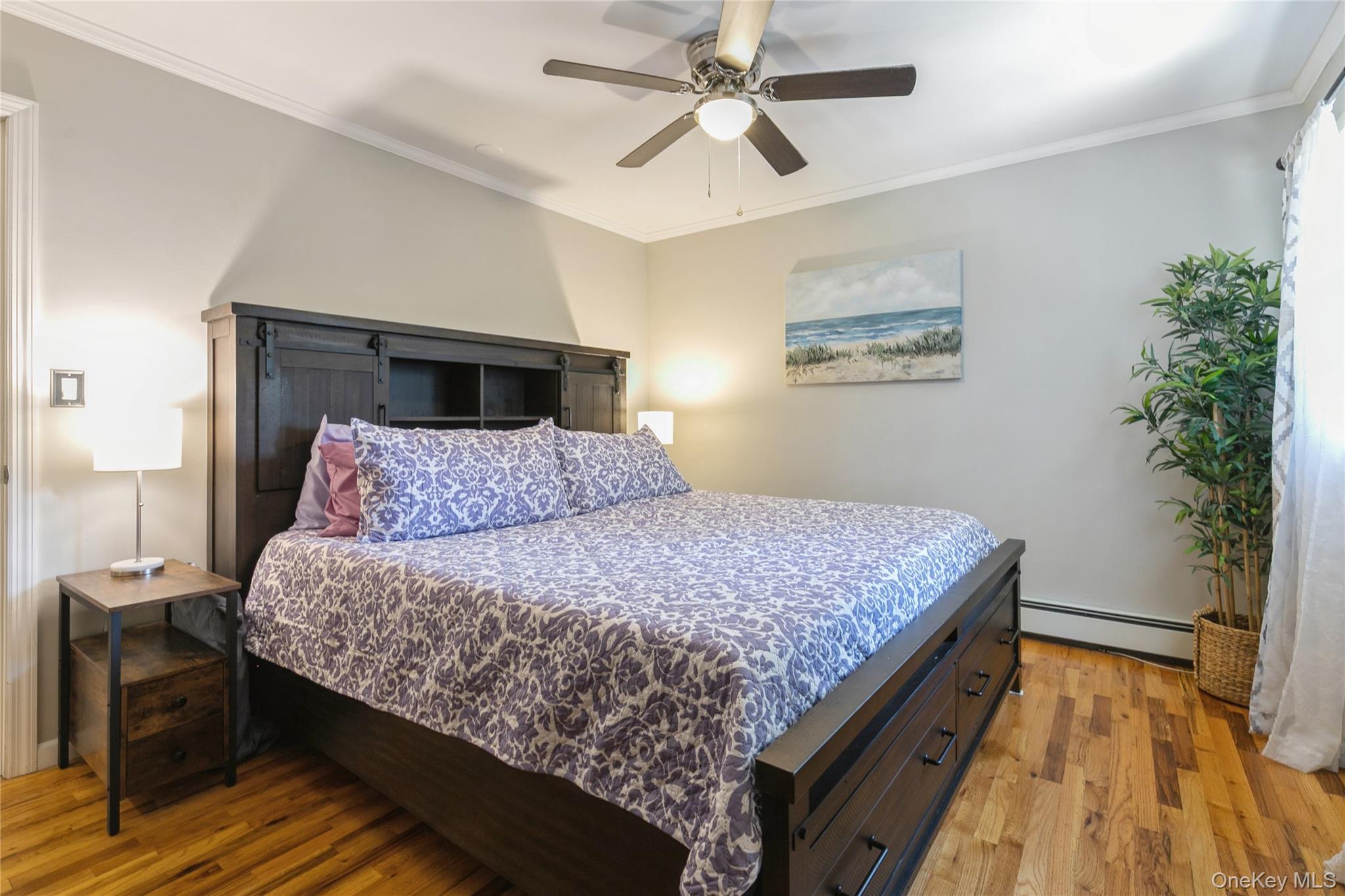 115 Clarendon Road Ronkonkoma, NY 11779 - Photo 16 of 45 Hardwood flooring throughout featuring a ceiling fan with integrated lighting, crown molding, and a window with natural light