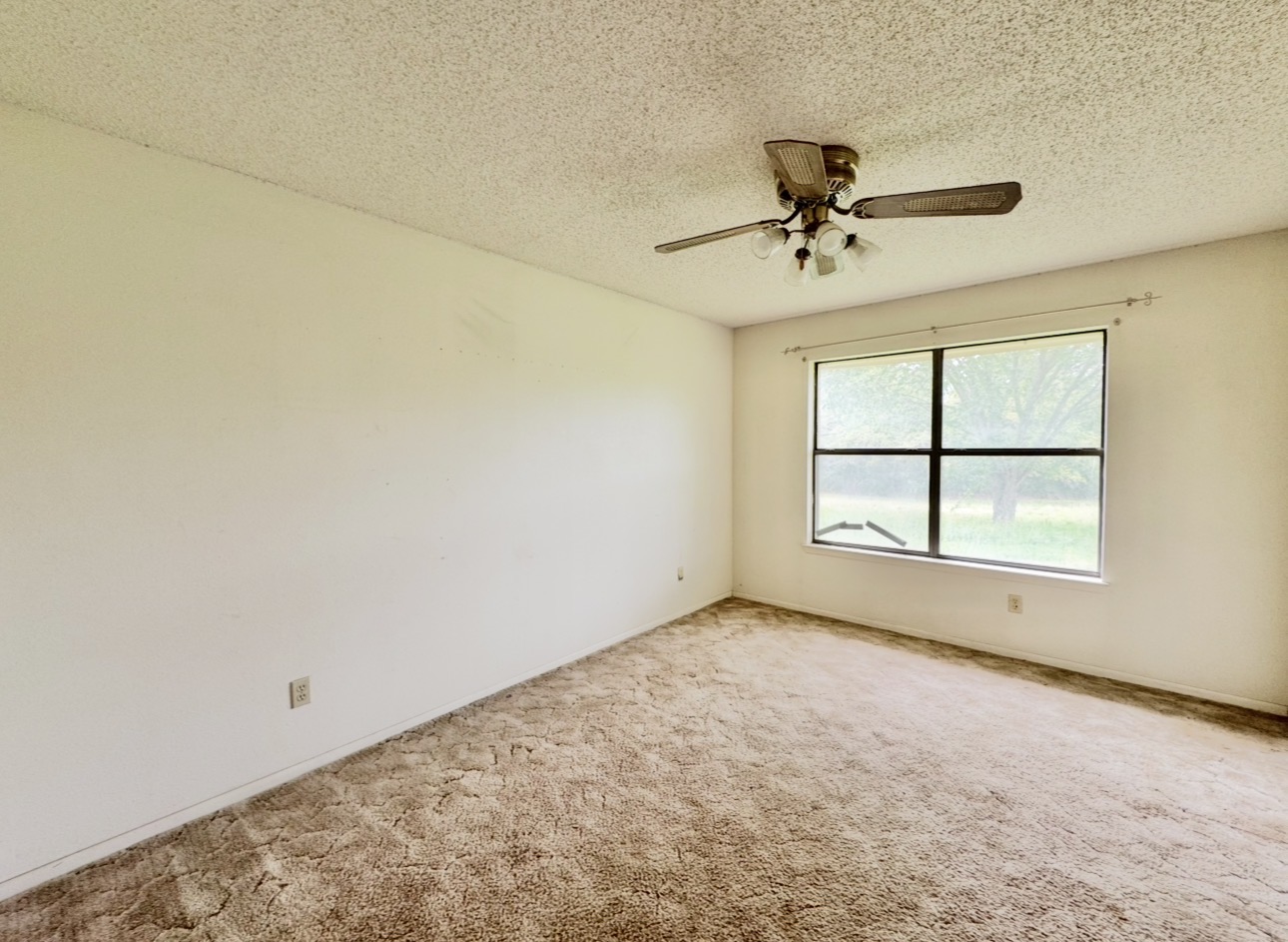 2410 State Highway 95 Elgin, TX 78621 - Photo 27 of 38 an empty room with a window and a ceiling fan