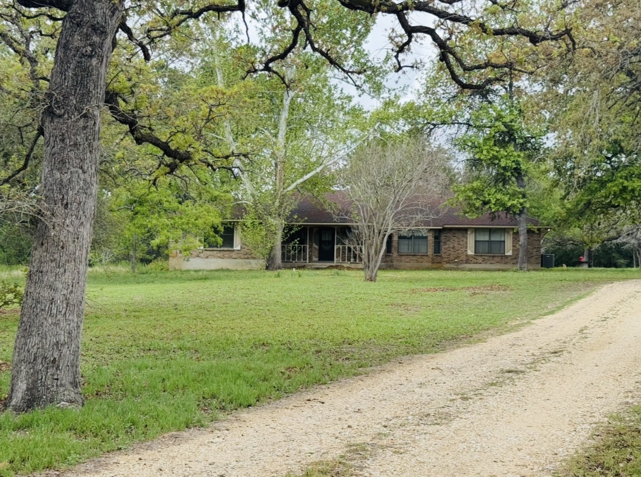 2410 State Highway 95 Elgin, TX 78621 - Photo 3 of 38 a front view of a house with a garden