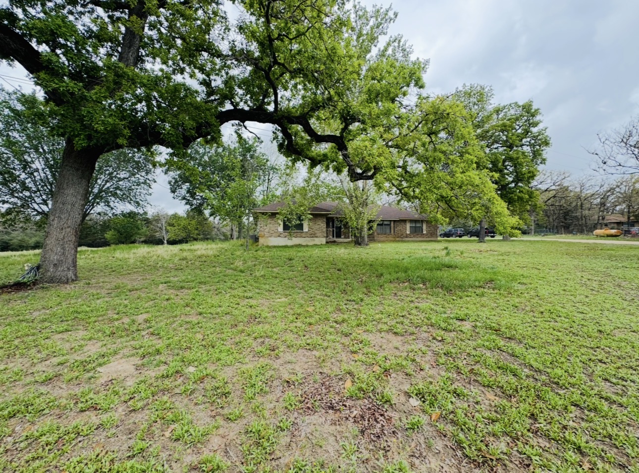 2410 State Highway 95 Elgin, TX 78621 - Photo 35 of 38 a backyard of a house with lots of green space and fountain