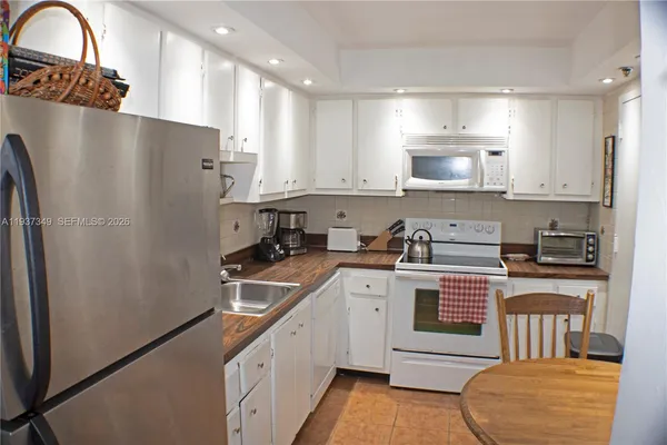 a kitchen with stainless steel appliances a refrigerator sink and cabinets