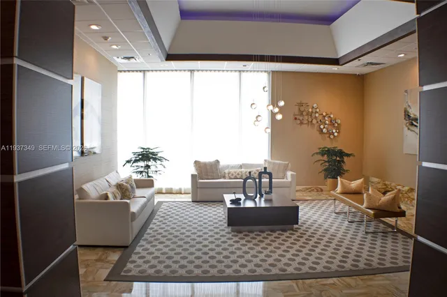 a living room with couches and kitchen view