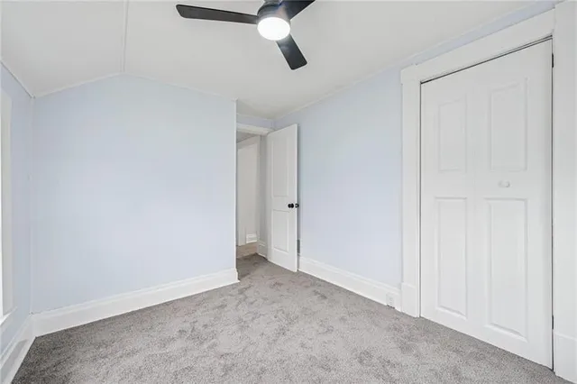 an empty room with closet and windows