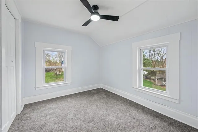 an empty room with a window and a ceiling fan