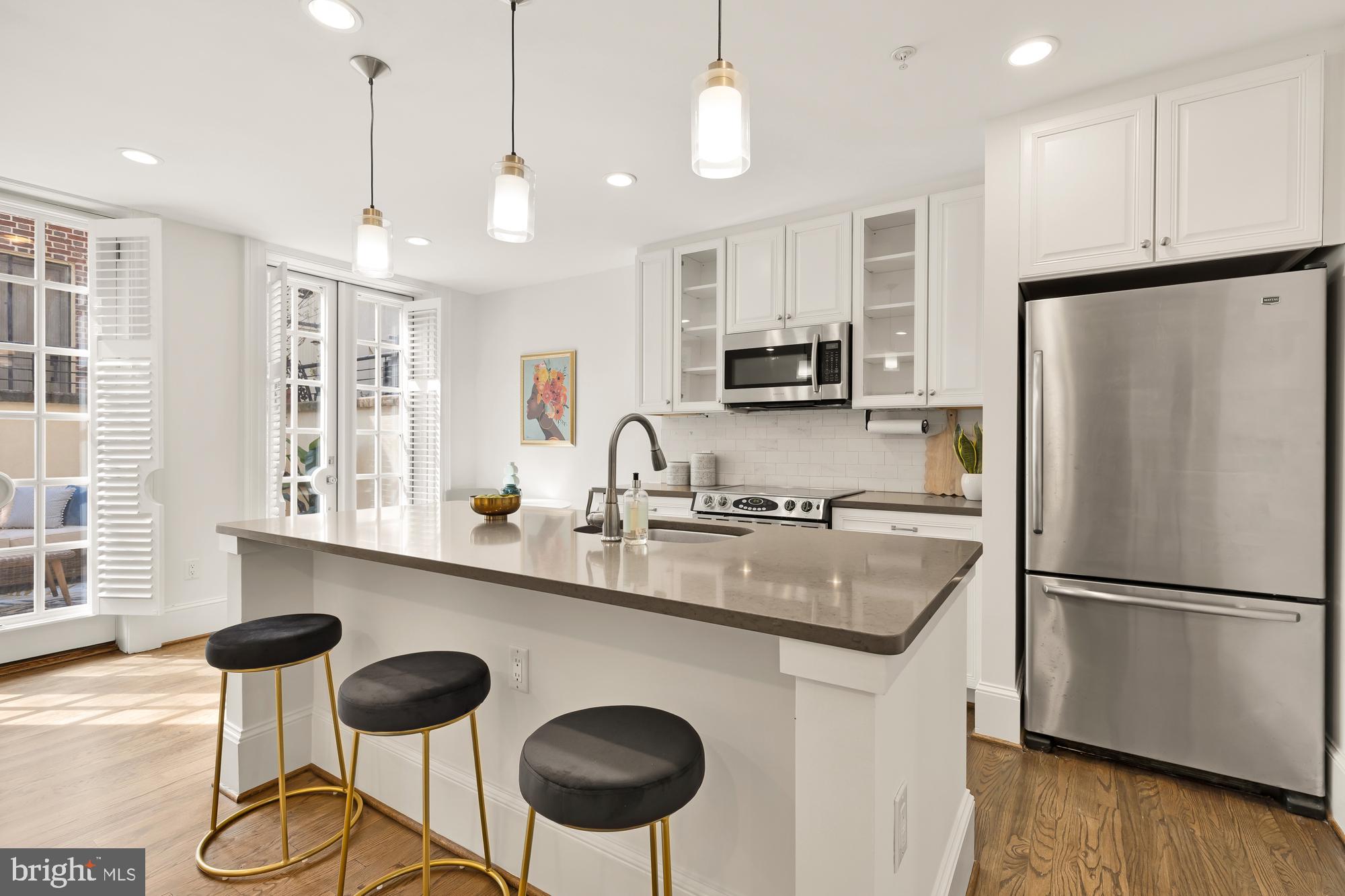 3324 18th Street Northwest, Unit 6 Washington, DC 20010 - Photo 9 of 24 a kitchen with stainless steel appliances granite countertop a sink a stove a refrigerator and island with wooden floor
