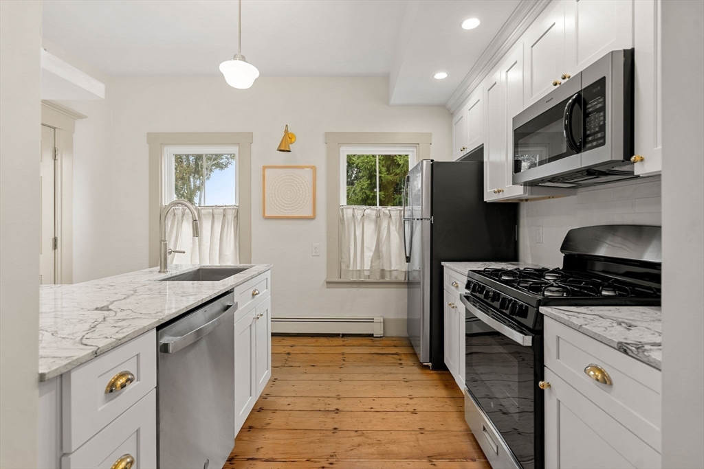 6 Mt Vernon Street, Unit 1 Marblehead, MA 01945 - Photo 2 of 14 a kitchen with stainless steel appliances granite countertop a stove a sink and a microwave