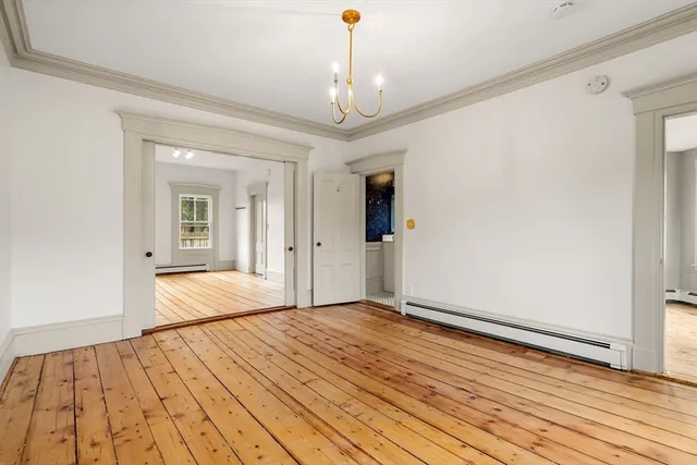 a bedroom with wooden floor chandelier and closet