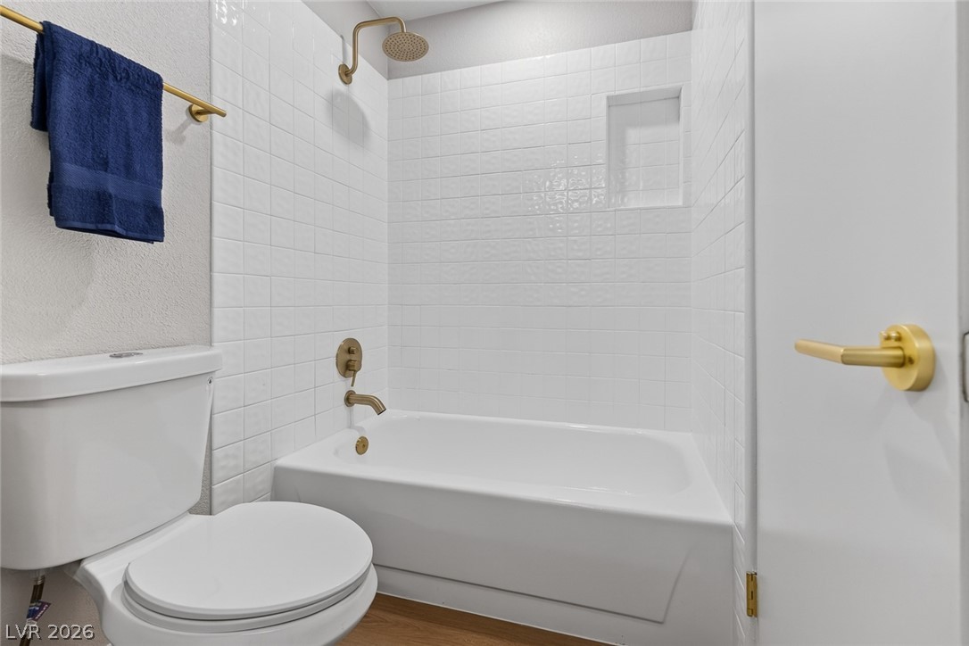 2484 Anglia Street Las Vegas, NV 89142 - Photo 16 of 20 This clean and bright bathroom features a modern shower-tub combination and a sleek toilet.