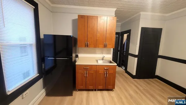 a kitchen with stainless steel appliances a refrigerator and a wooden floor
