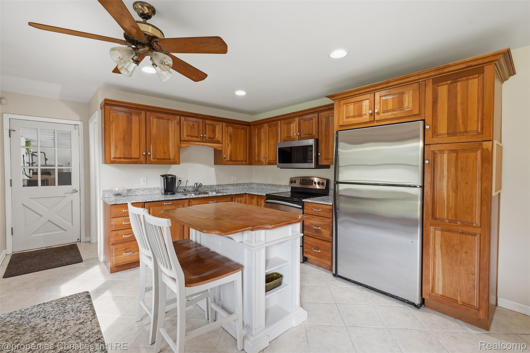 4030 Textile Road Ypsilanti, MI 48197 - Photo 14 of 58 Wood cabinetry, stainless steel appliances, granite countertops, kitchen island, and ceramic tile flooring