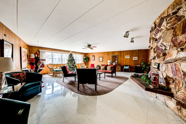 a living room with furniture a rug and a book shelf